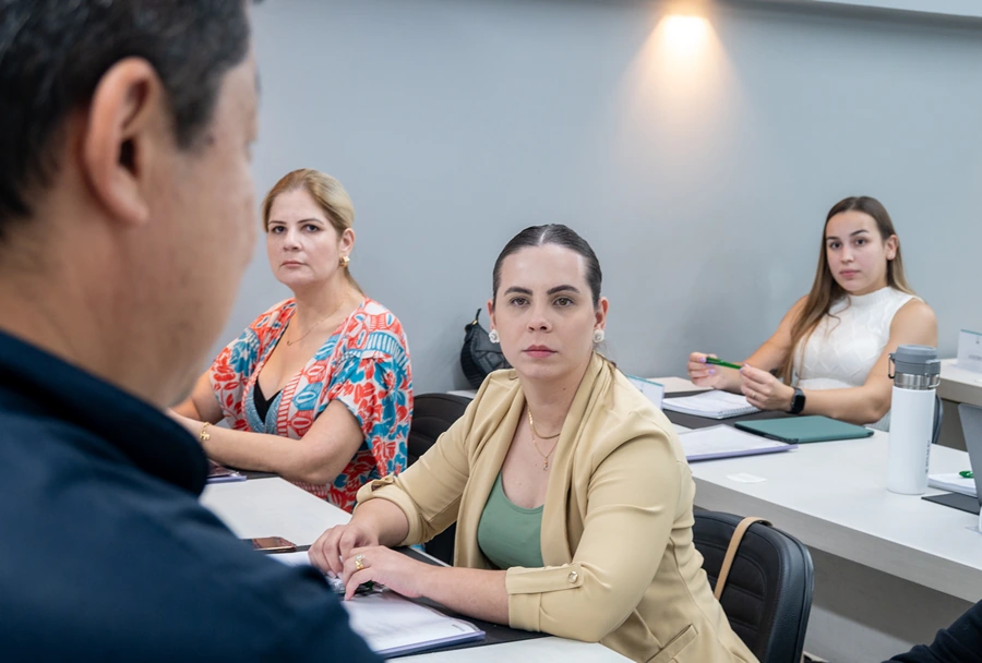 Aluna focada em ouvir o instrutor durante uma sessão do curso de Implantodontia no Instituto IPPO, em ambiente de sala de aula.