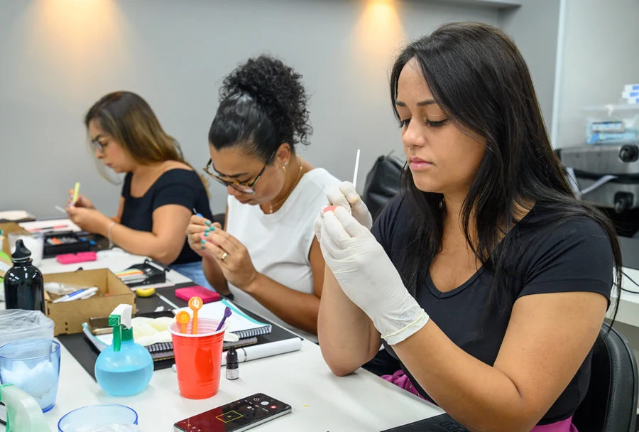 Sala de aula do Instituto IPPO com alunos realizando atividades práticas odontológicas sob supervisão, com uso de lupas e ferramentas específicas.